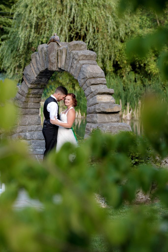 a bride and groom under the stone arch

