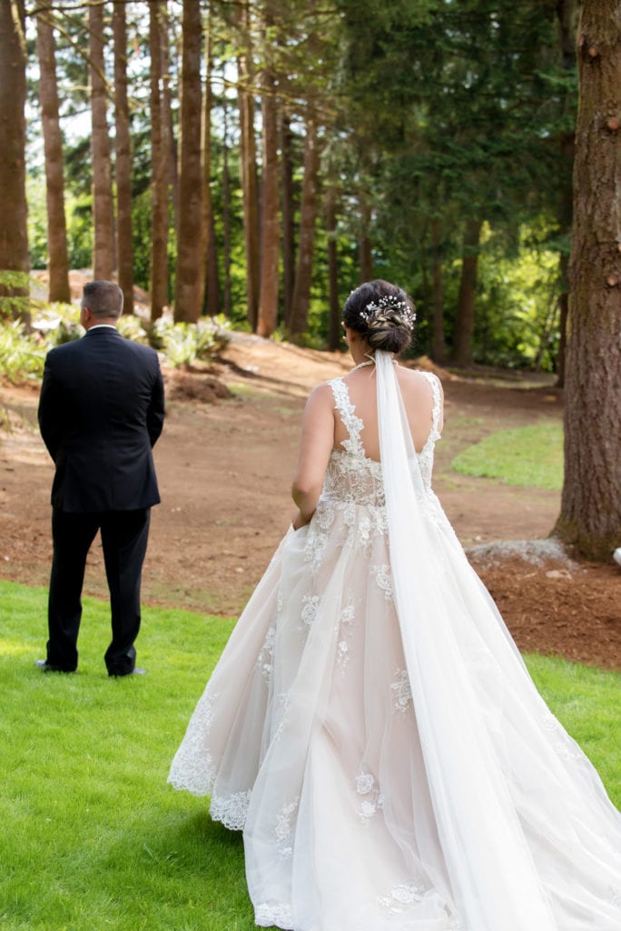 a bride walks up behind the groom for their first look