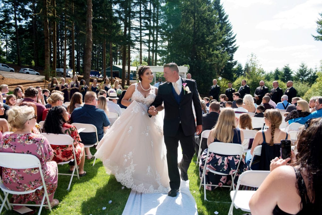 a bride and groom happily walk down the aisle as husband and wife
