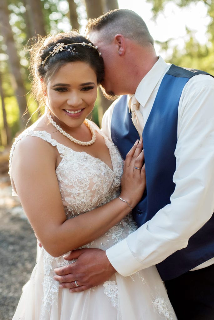 bride and groom pose together during their brush prairie backyard wedding