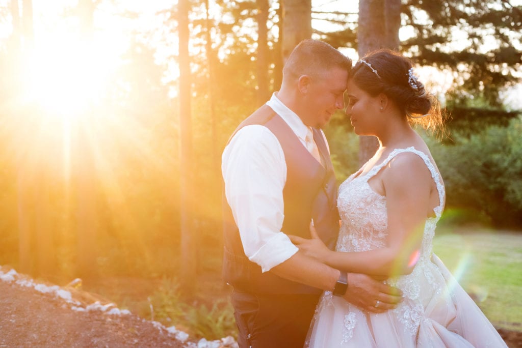 a bride and groom are bathed in sunlight as they pose for portraits after their brush prairie backyard wedding