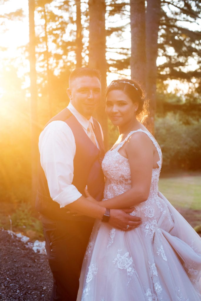 a bride and groom are bathed in sunlight as they pose for portraits after their brush prairie backyard wedding