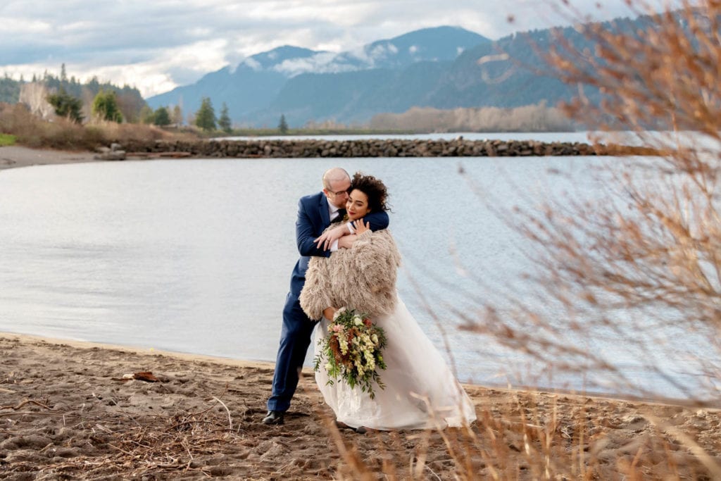 bride and groom with presentation style bouquet along columbia river in hood river